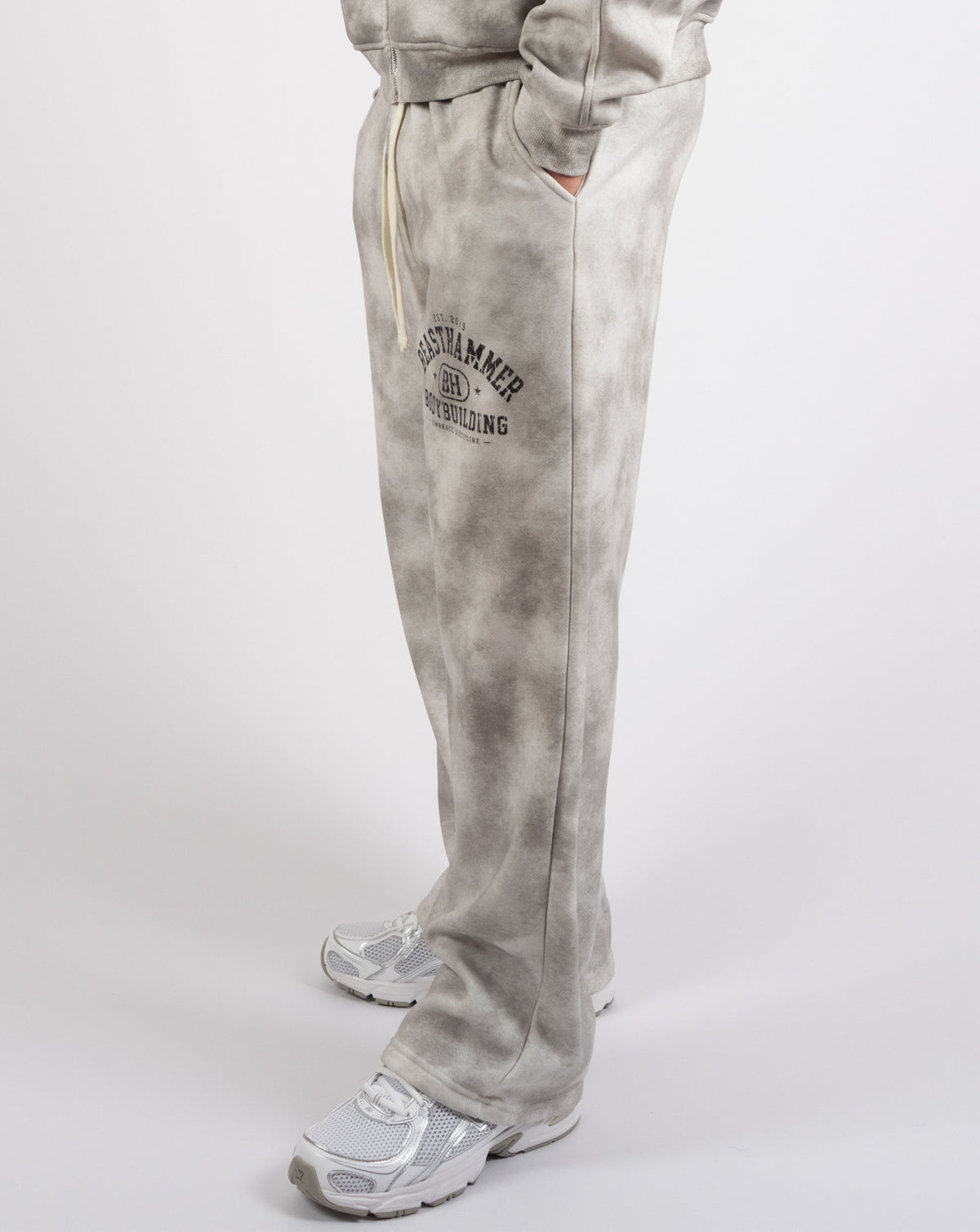 BEASTHAMMER Formed by Discipline baggy joggers in faded grey, worn side view of the wide straight leg