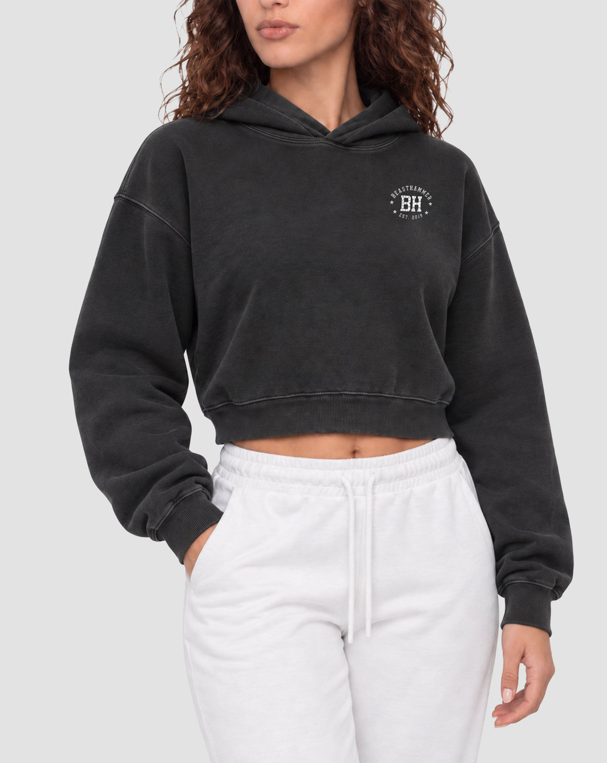 BEASTHAMMER Rest washed boxy hoodie in black, worn front view showing the boxy cropped fit and the BH badge on the chest