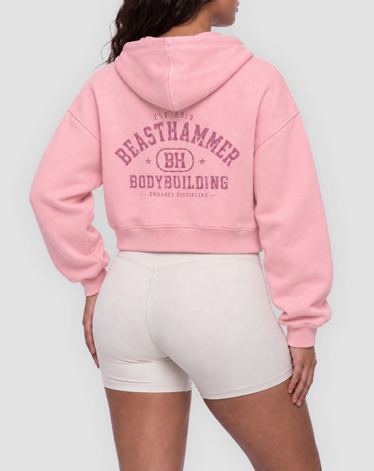 BEASTHAMMER Rest washed boxy hoodie in pink, worn back view with the collegiate BEASTHAMMER BODYBUILDING arch print