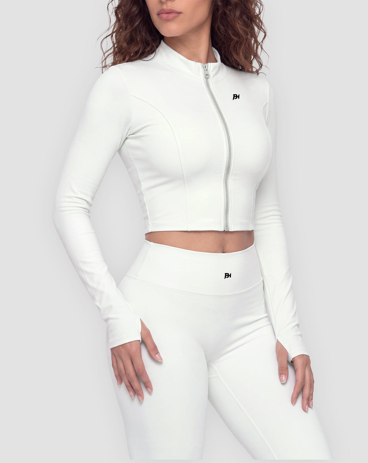 BEASTHAMMER Signature crop jacket in white, worn front view with stand collar, full zip and BH monogram