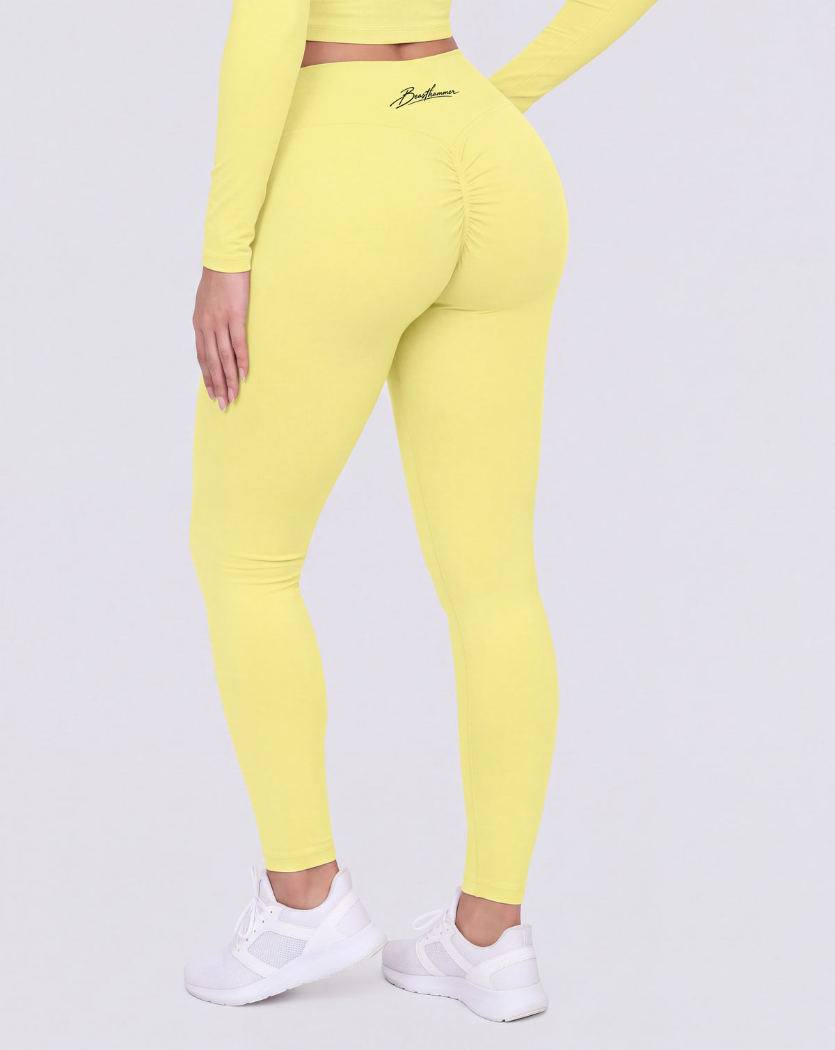 BEASTHAMMER Signature scrunch leggings in butter yellow, worn back view showing the scrunch seam and the high-rise waistband