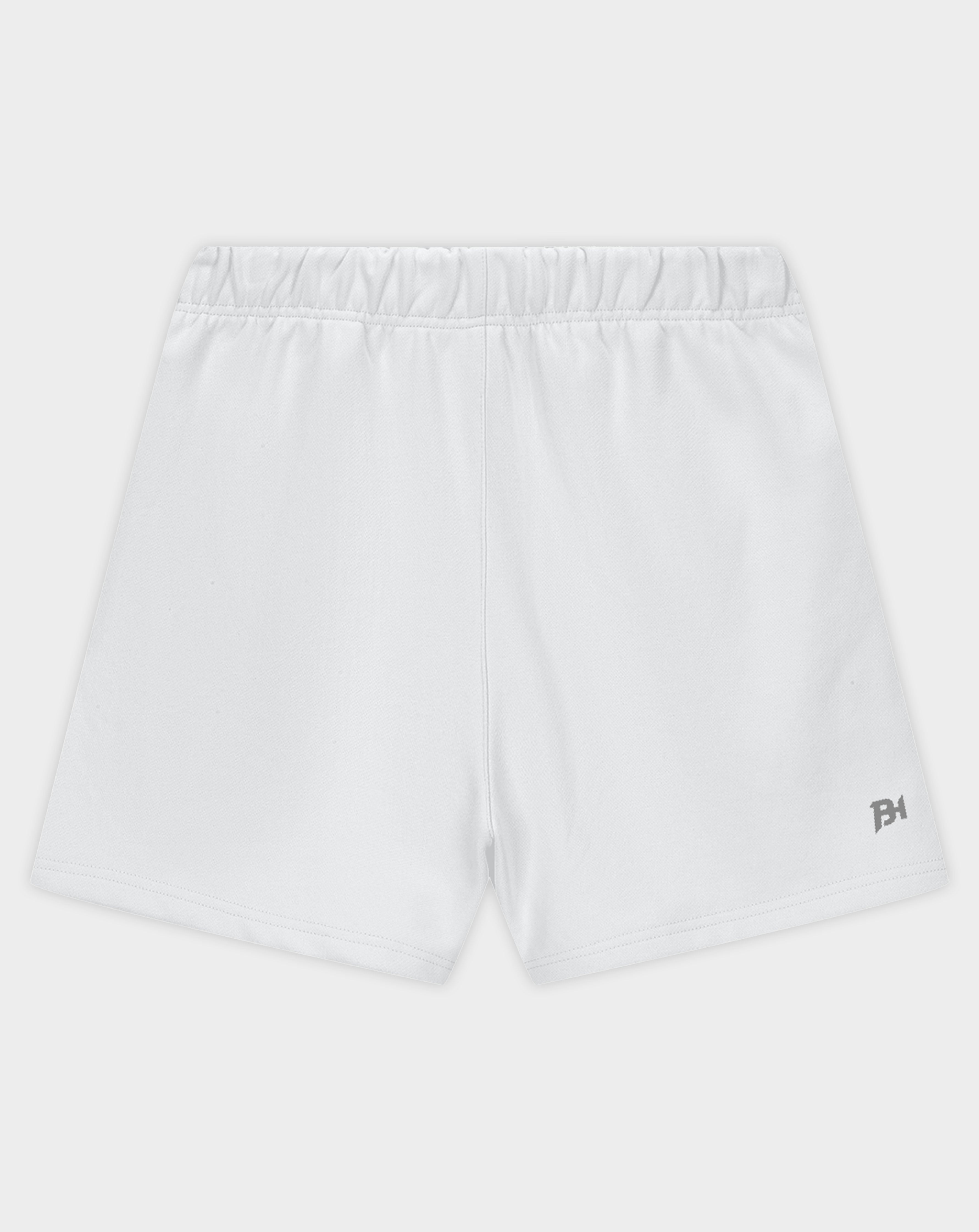White athletic shorts with an elastic waistband and a small dark gray logo on the lower left hem, shown against a light gray background.