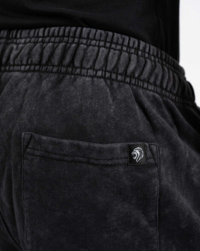 BEASTHAMMER Embrace Discipline cuffed joggers in washed black, close-up of the back pocket and logo badge