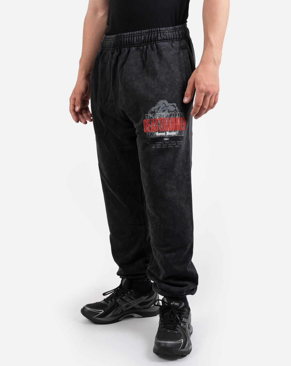BEASTHAMMER Embrace Discipline cuffed joggers in washed black, worn front view with the red BEASTHAMMER thigh print
