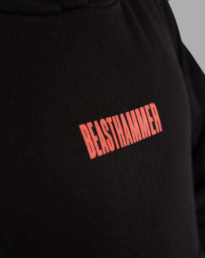 BEASTHAMMER Embrace Discipline boxy hoodie in black, close-up of the red BEASTHAMMER chest logo