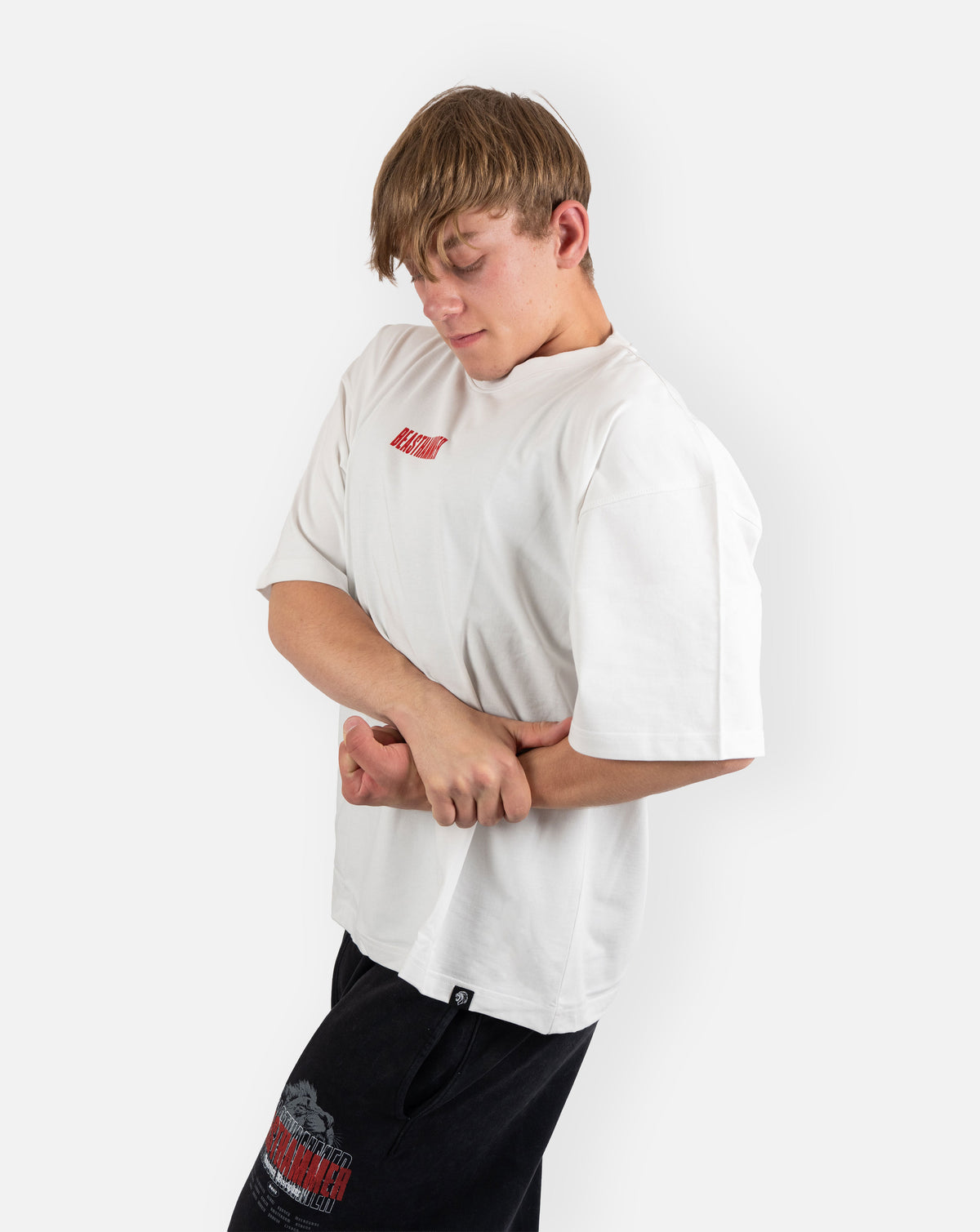 BEASTHAMMER Embrace Discipline oversized tee in white, worn three-quarter front view showing the boxy fit