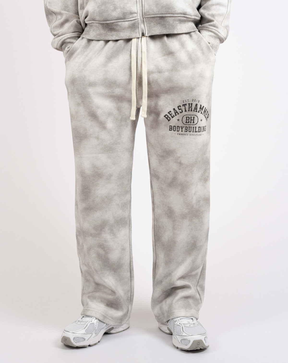 BEASTHAMMER Formed by Discipline baggy joggers in faded grey, worn front view with drawstring waist