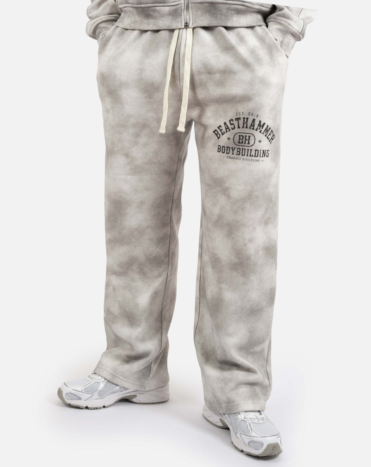 BEASTHAMMER Formed by Discipline baggy joggers in faded grey, worn front view with thigh print