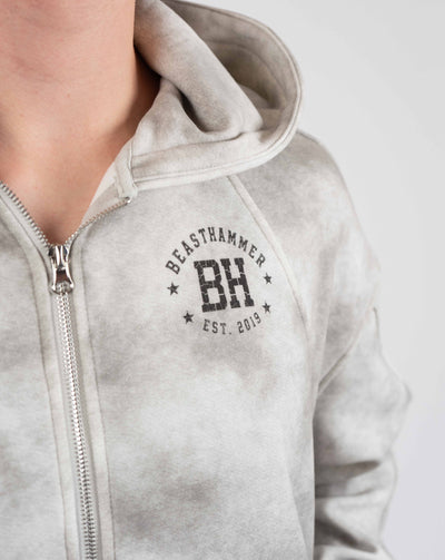 BEASTHAMMER Formed by Discipline zip hoodie in faded grey, close-up of the BH chest logo
