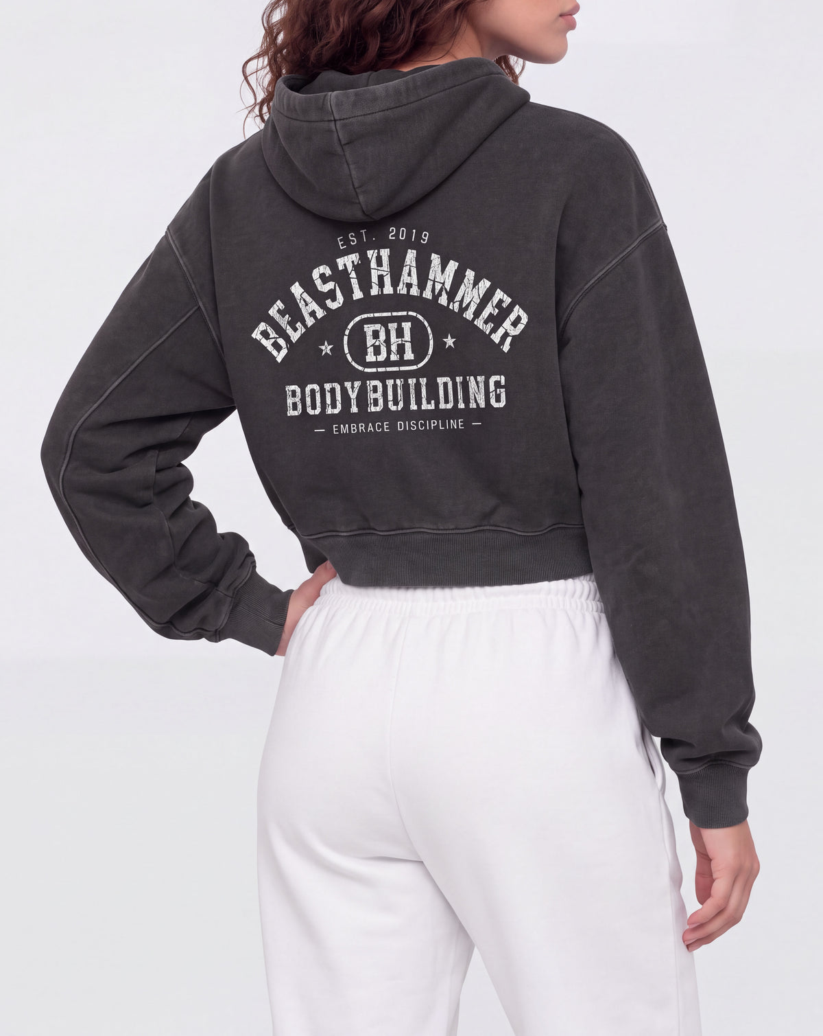 BEASTHAMMER Rest washed boxy hoodie in black, worn back view with the collegiate BEASTHAMMER BODYBUILDING arch print