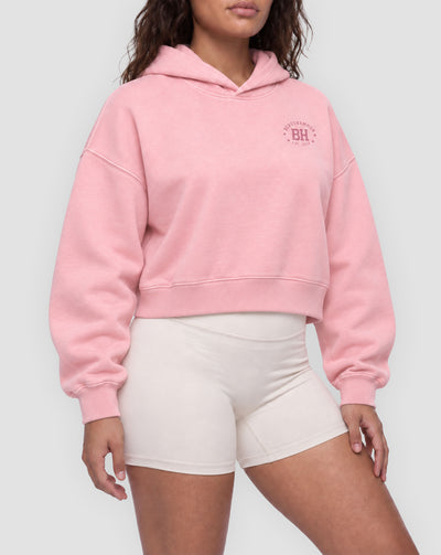 BEASTHAMMER Rest washed boxy hoodie in pink, worn front view showing the boxy cropped fit and the BH badge on the chest