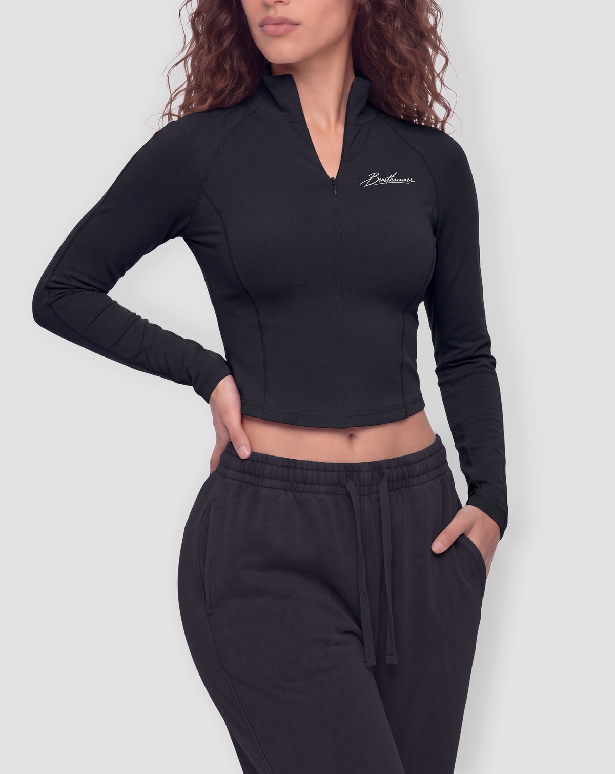 BEASTHAMMER Signature quarter zip top in black, worn front view with stand collar and the handwritten Beasthammer script on the chest