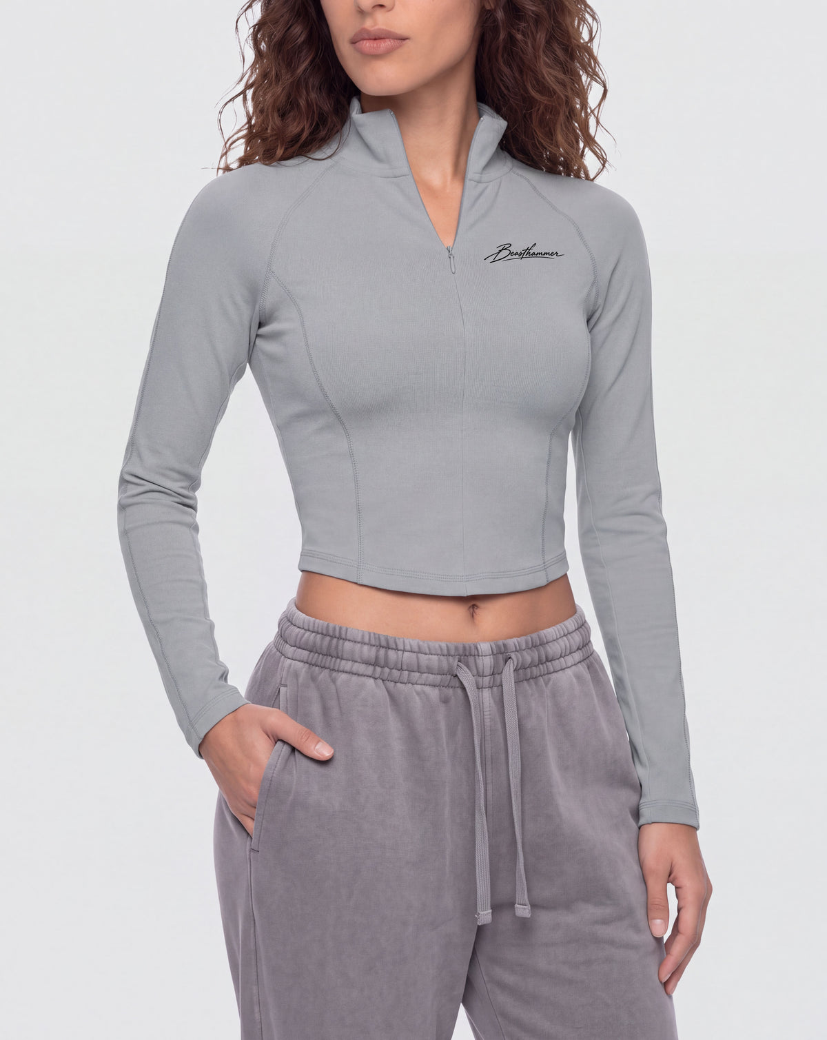 BEASTHAMMER Signature quarter zip top in grey, worn front view with stand collar and the handwritten Beasthammer script on the chest