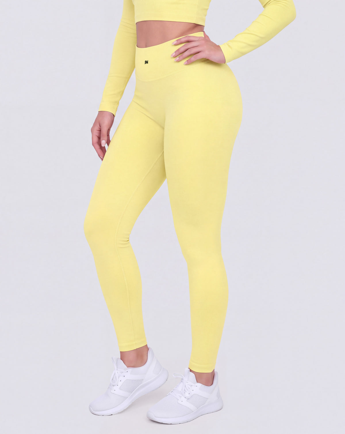 BEASTHAMMER Signature scrunch leggings in butter yellow, worn front three-quarter view showing the high-rise waistband and ankle length