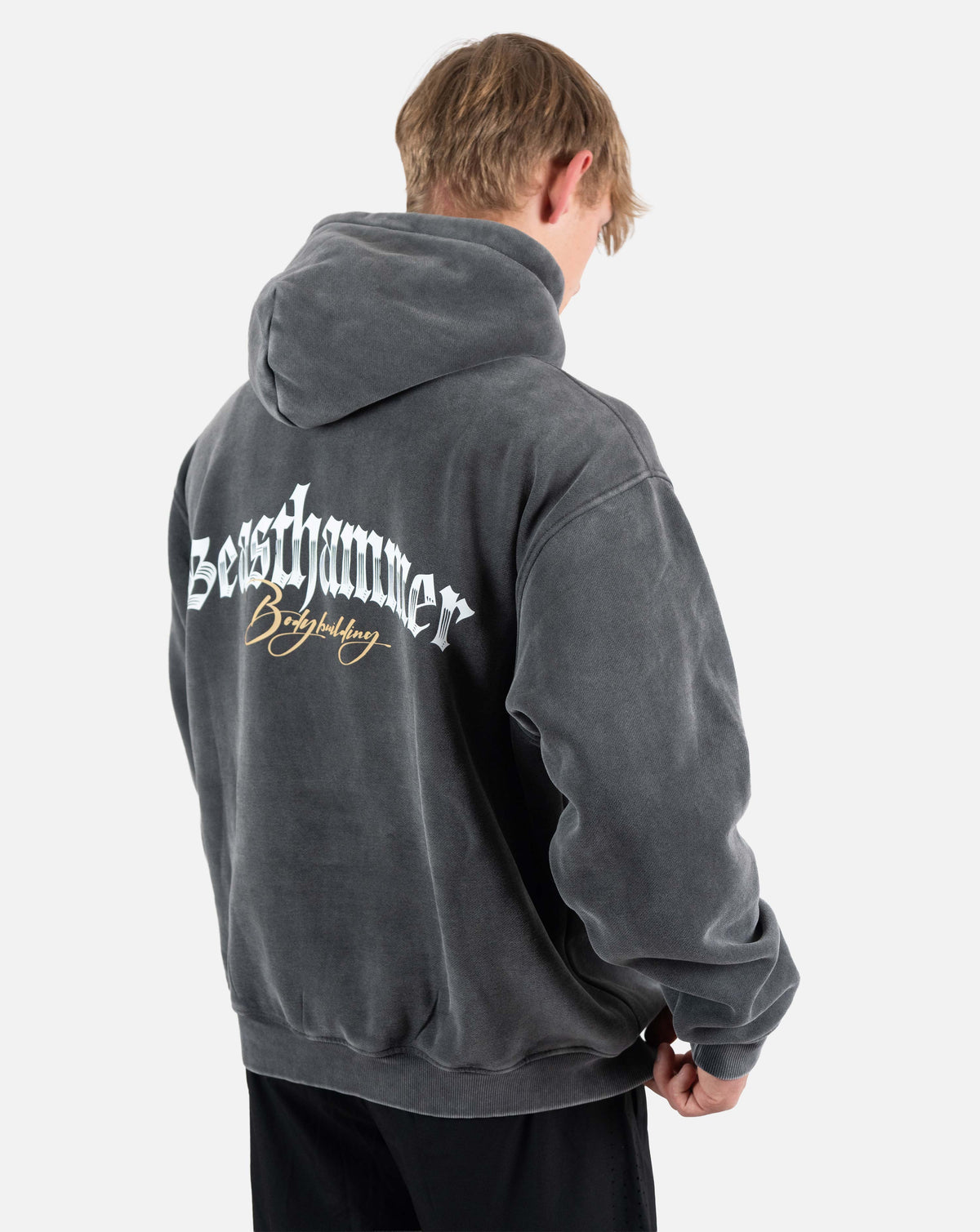 BEASTHAMMER Snow Wash oversized hoodie in washed black, worn back three-quarter view with the back print