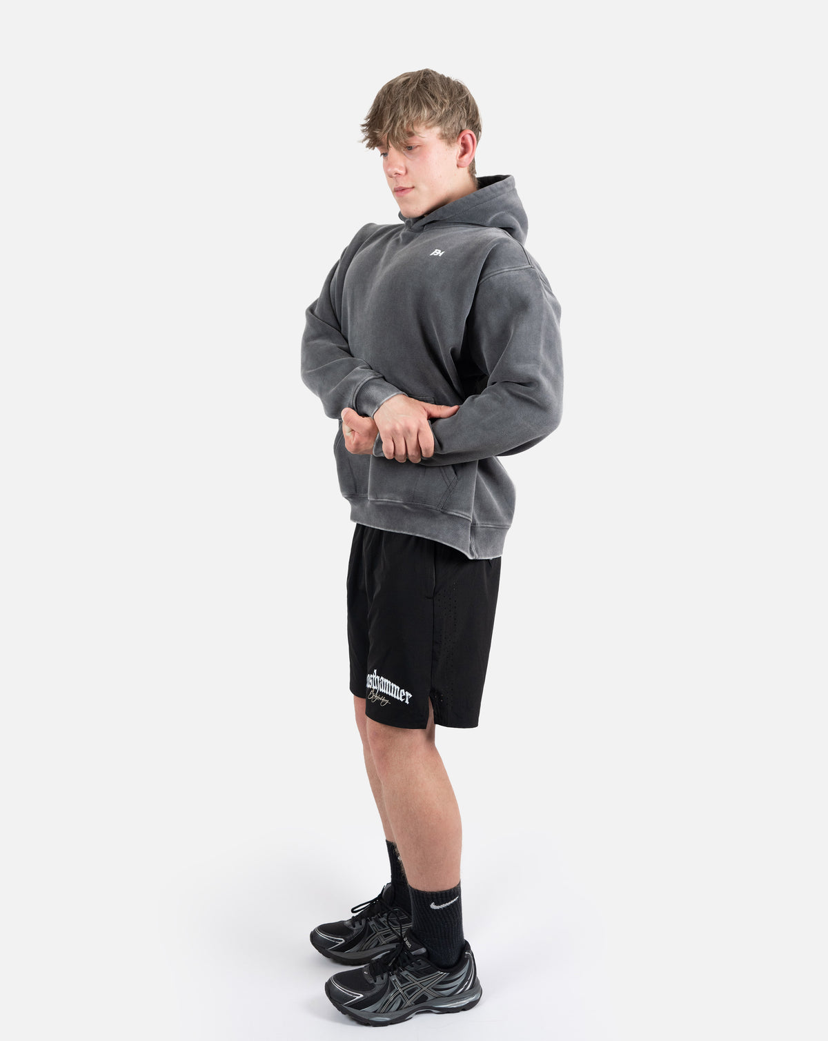 BEASTHAMMER Snow Wash oversized hoodie in washed black, full-length side view showing the drop shoulder and relaxed length