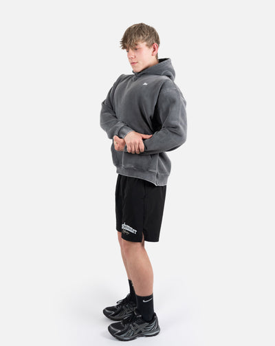 BEASTHAMMER Snow Wash oversized hoodie in washed black, full-length side view showing the drop shoulder and relaxed length