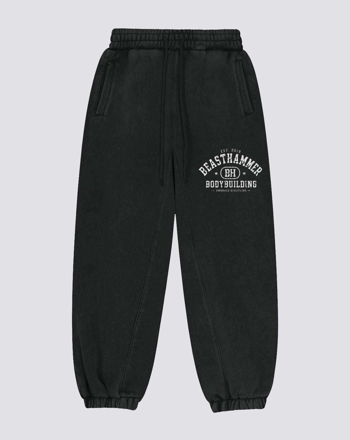 BEASTHAMMER Snow Wash cuffed joggers in black, flat front view with the arched BEASTHAMMER print on the thigh