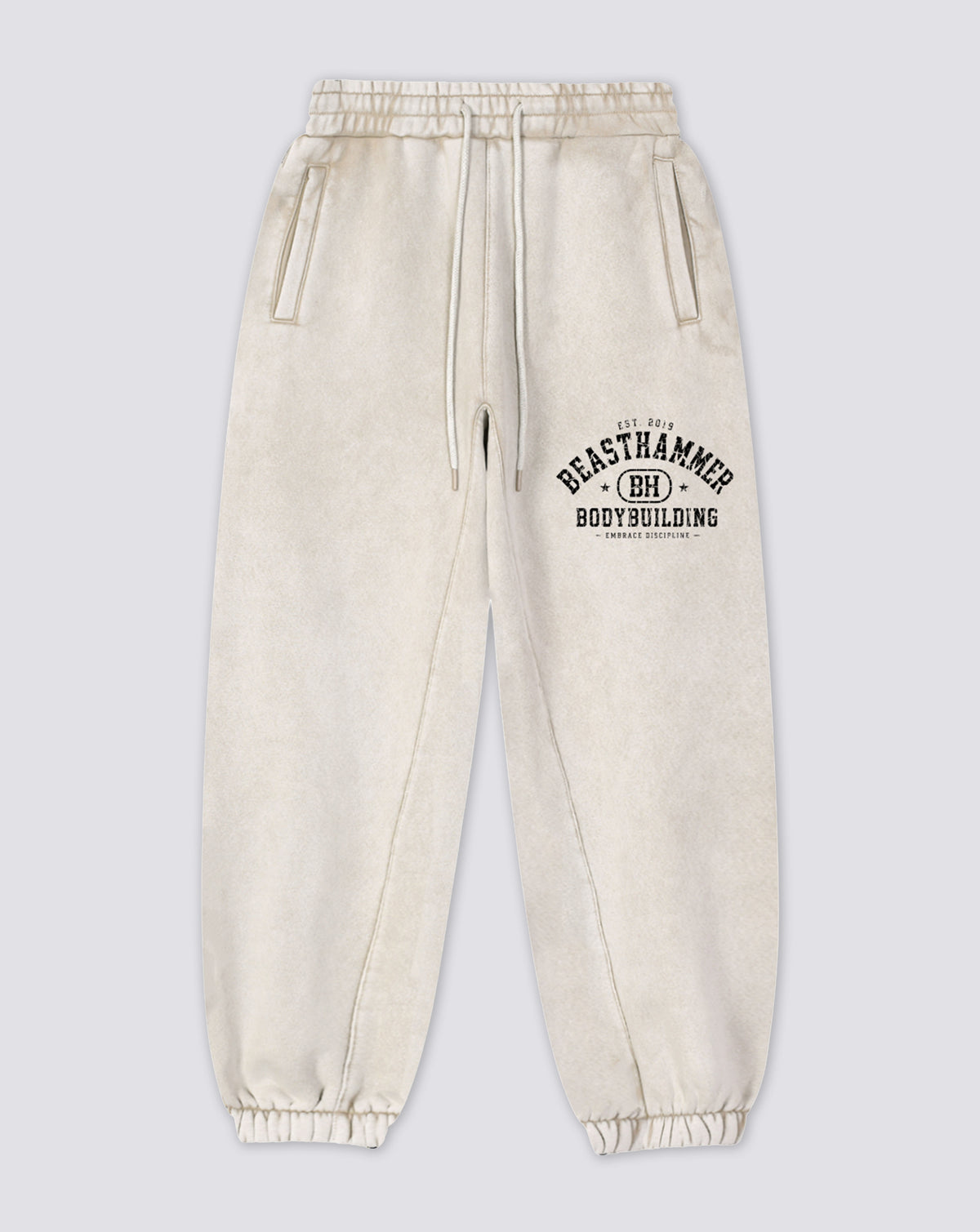 BEASTHAMMER Snow Wash cuffed joggers in bone, flat front view with the arched BEASTHAMMER print on the thigh