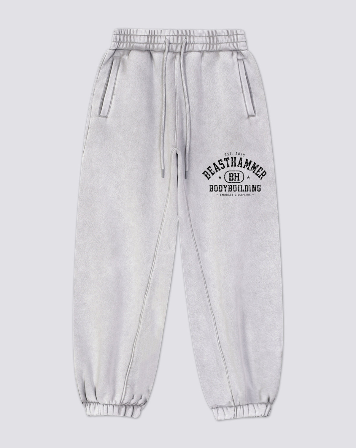 BEASTHAMMER Snow Wash cuffed joggers in grey, flat front view with the arched BEASTHAMMER print on the thigh