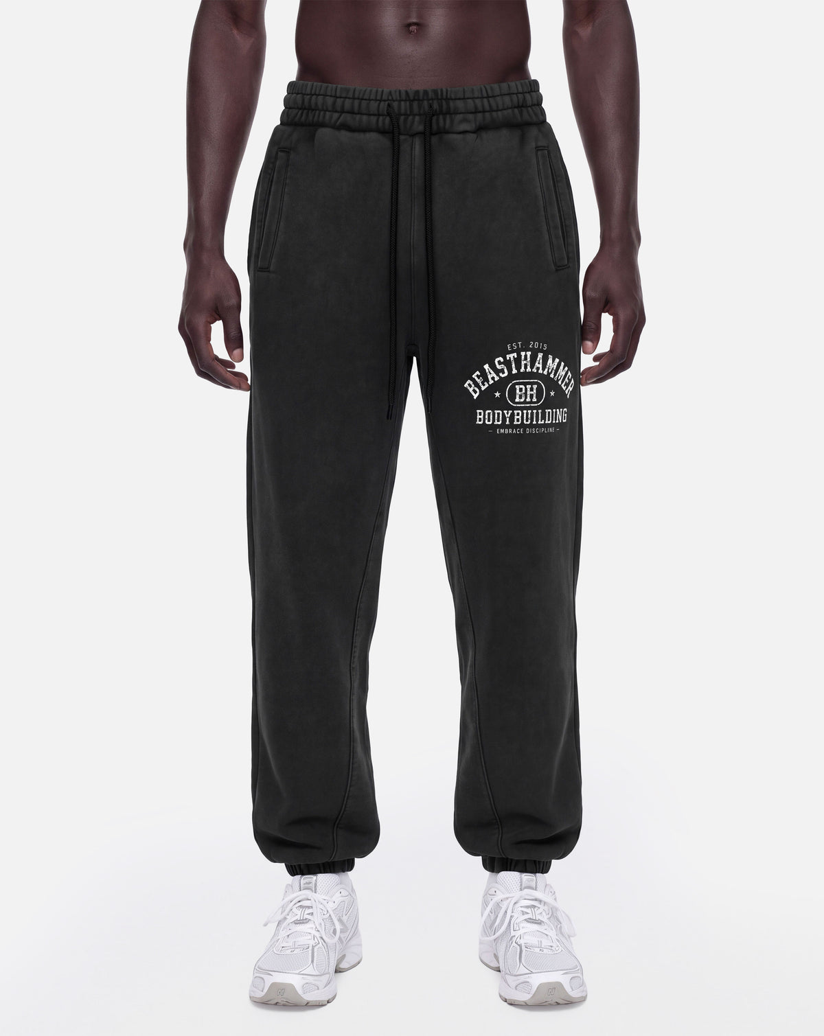 BEASTHAMMER Snow Wash cuffed joggers in black, worn front left angle view