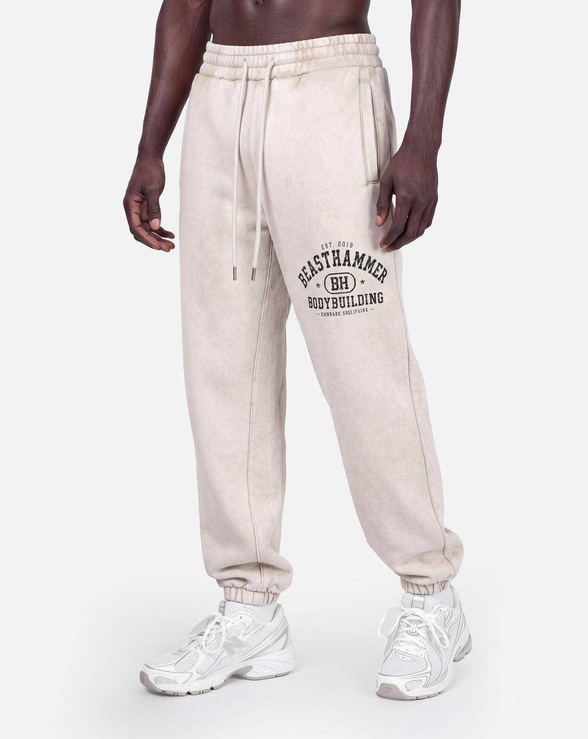 BEASTHAMMER Snow Wash cuffed joggers in bone, worn front left angle view