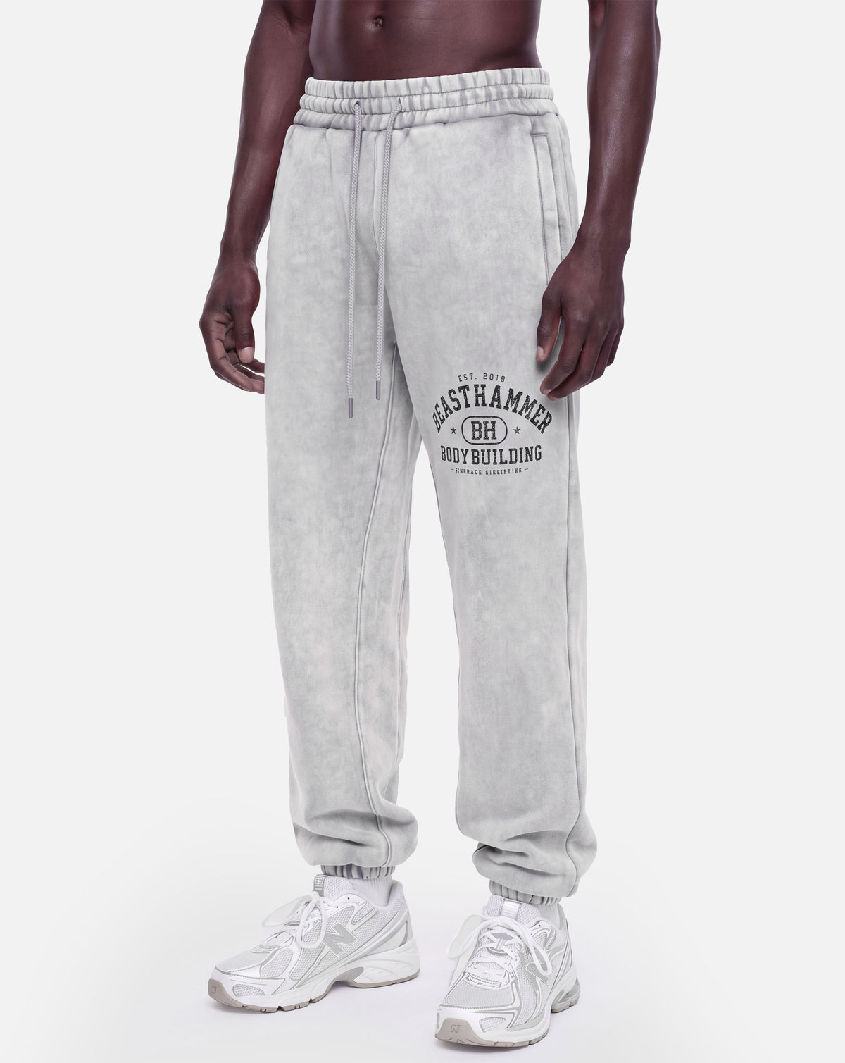 BEASTHAMMER Snow Wash cuffed joggers in grey, worn front left angle view