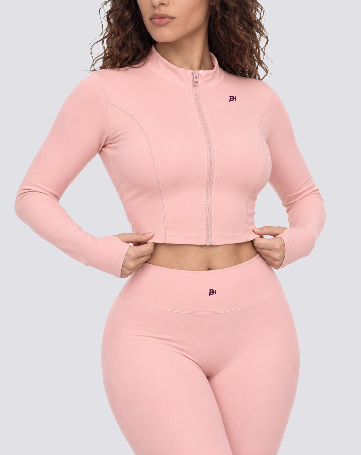 BEASTHAMMER Signature crop jacket in pink, worn front view with stand collar, full zip and BH monogram, styled with matching Signature scrunch leggings