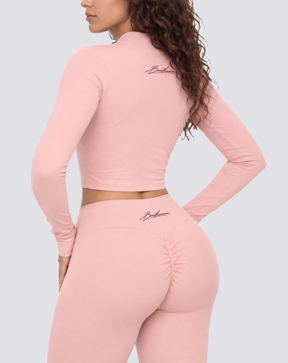 BEASTHAMMER Signature crop jacket in pink, worn back three-quarter view with matching Signature scrunch leggings