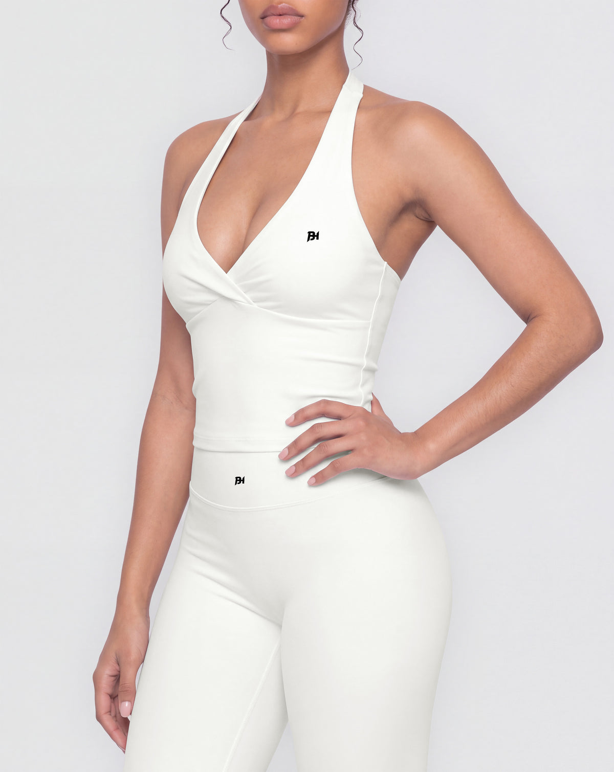 BEASTHAMMER Signature halter top in white, worn front view with halter neck, ruched twist and BH monogram