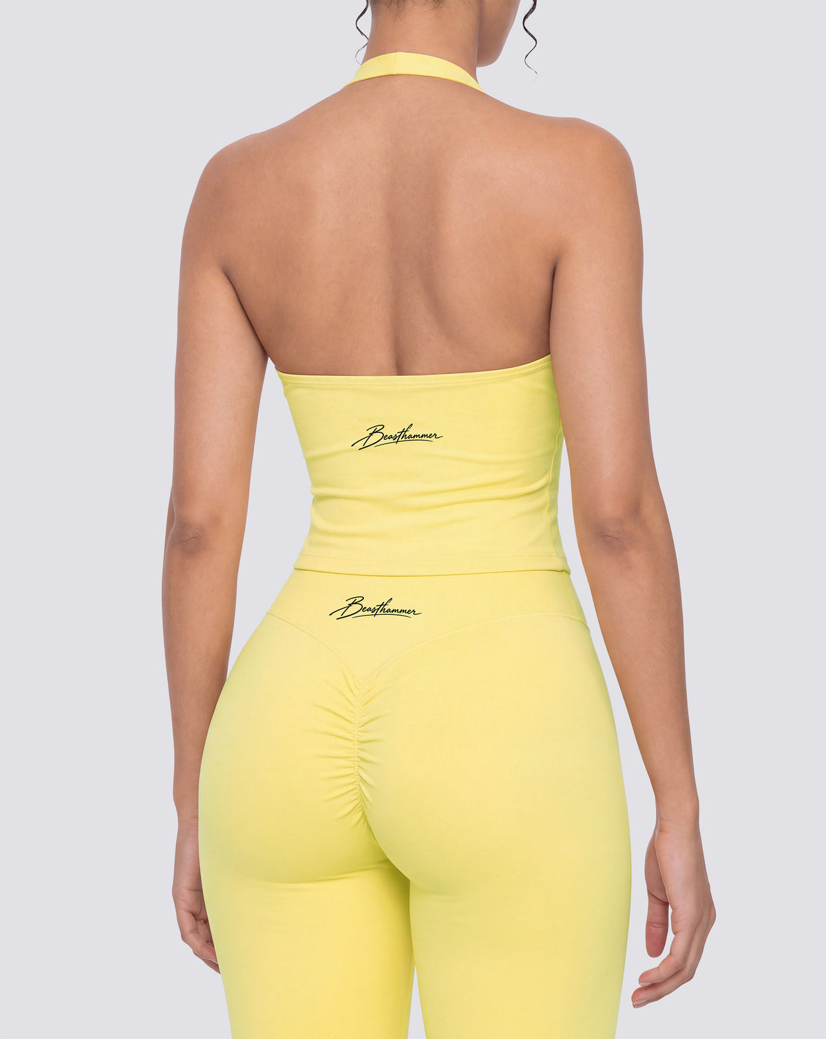 BEASTHAMMER Signature halter top in butter yellow, worn back view with open halter back and the handwritten Beasthammer script logo