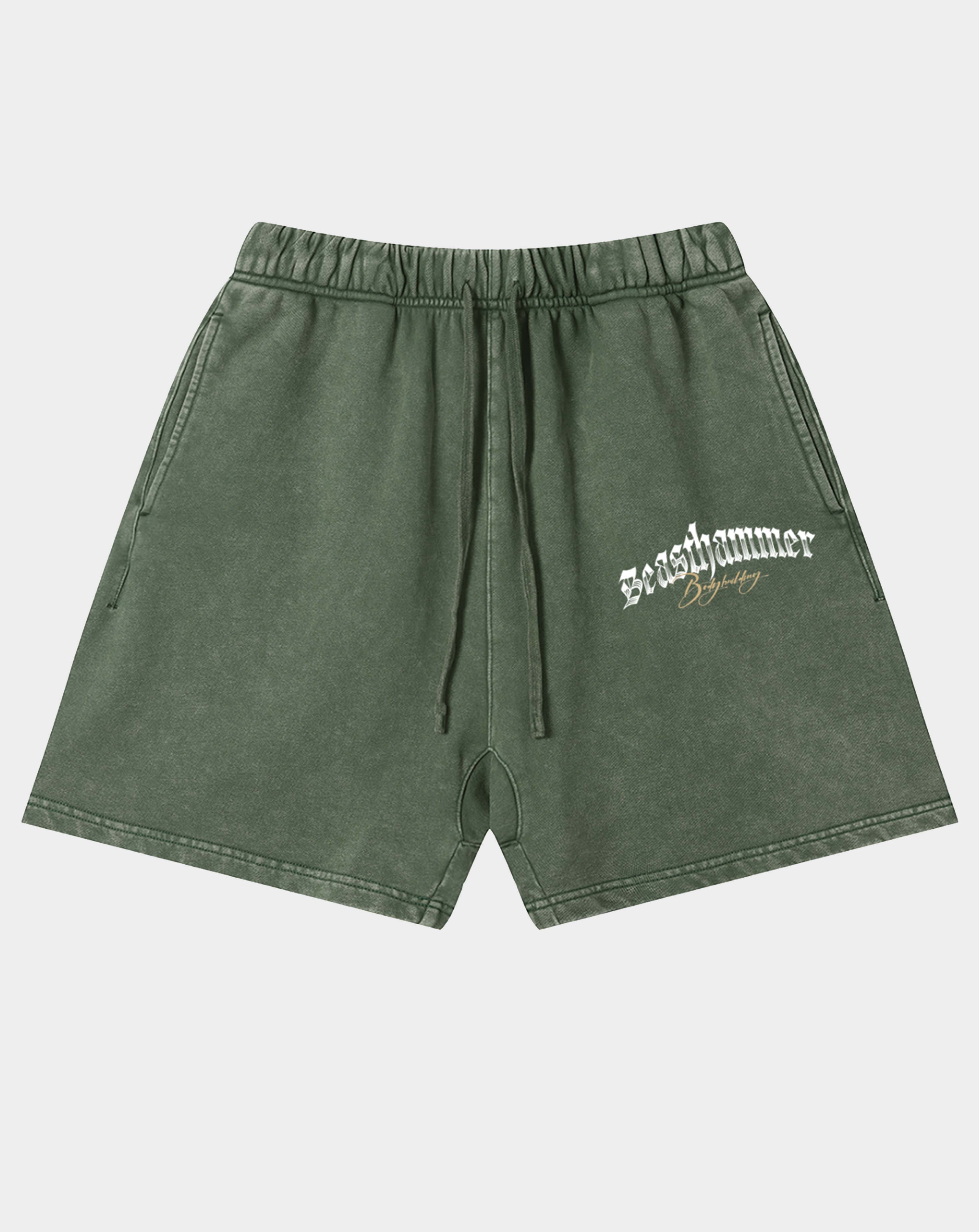 Olive green acid-wash shorts with a drawstring waist and a white 'seashammer' logo printed on the left leg, shown against a light gray background.